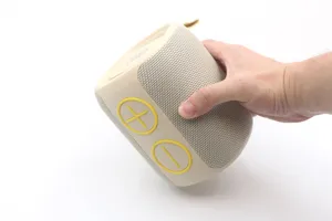 Vista di dettaglio di un mini altoparlante Bluetooth portatile con tessuto e tasti.