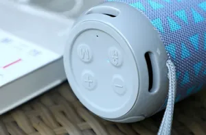 Altoparlante Bluetooth wireless portatile con rivestimento in tessuto e tasti di controllo.