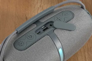 Portable wireless bluetooth speaker with fabric mesh, rubber buttons and multiple ports.