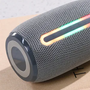 Primer plano detallado del altavoz bluetooth gris cilindrico con la tira de luz rgb.