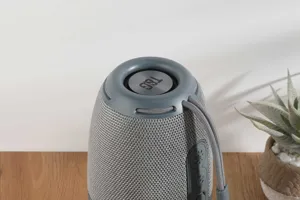 Close-up detail of the portable wireless Bluetooth speaker showing fabric mesh and top controls.