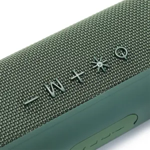 Nahaufnahme Detail der grünen Stoff-Mesh Textur und kabellosen Bluetooth-Lautsprecher Tasten.