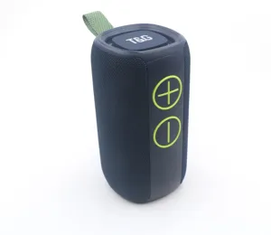 Close-up detail of the portable blue bluetooth speaker, showing mesh texture and green buttons.