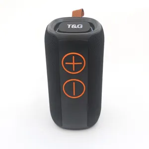 Detail shot of the black wireless Bluetooth speaker with orange buttons and portable strap.