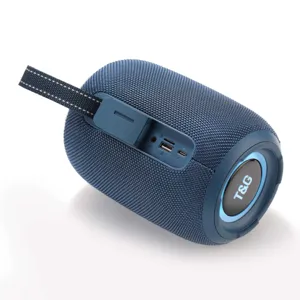 Détail d'enceinte Bluetooth portable montrant le corps en tissu mesh bleu et les ports.