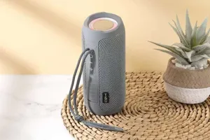 Portable wireless bluetooth speaker with fabric mesh, deep bass, waterproof and lanyard design.