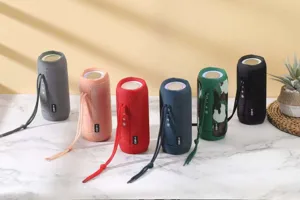 Portable wireless Bluetooth speaker with fabric mesh and waterproof design, multi-color options.