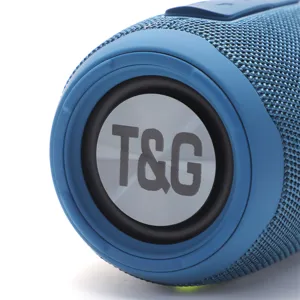 Portable bluetooth speaker detail shot featuring blue fabric mesh and passive bass radiator.
