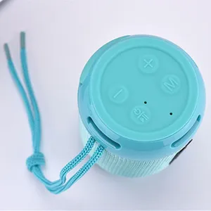 Portable wireless Bluetooth speaker with hanging strap in vibrant cyan, compact and stylish design.