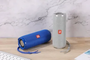 Detailansicht des tragbaren kabellosen Bluetooth-Lautsprechers mit Stoffgewebe und Tragegurt.