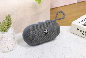 Primo piano dettagliato dell'altoparlante Bluetooth portatile in tessuto grigio.