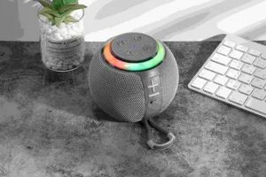 Portable wireless Bluetooth speaker detail view with colorful RGB light and fabric mesh.
