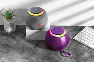 Detail view of portable spherical bluetooth speaker with colorful RGB light ring and control buttons.