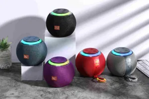 Portable mini Bluetooth speaker detail showing colorful LED light ring and fabric mesh design.