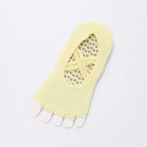 Detail of yellow five-toe yoga socks with cross straps and anti-slip dots for pilates workout.