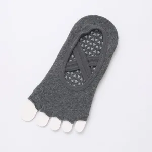 Detail view of dark grey five toe yoga socks with cross straps and anti slip grip soles.