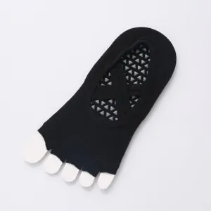 Black five toe yoga socks detail view featuring cross strap and anti slip grip sole design.