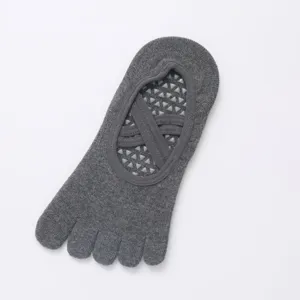 Detail view of grey five-toe yoga sock with cross straps and anti-slip silicone grip bottom.