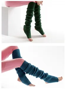 Close-up details of long knit yoga leg warmers showcasing textured ribbed design and stirrup feet.