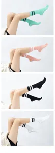 Details showing multi-color five toe non-slip grip yoga socks with double stripe design.
