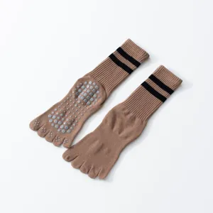 Detail shot of khaki non-slip toe yoga socks with black stripes and silicone grip dots.