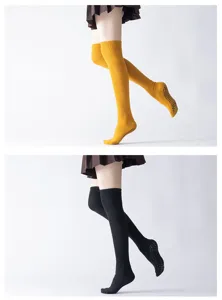 Detail view of over-the-knee yoga socks with non-slip grip soles and cozy ribbed knit design.