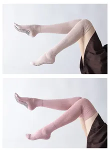 Detailed view of thermal over-the-knee yoga socks with anti-slip grip soles for pilates.