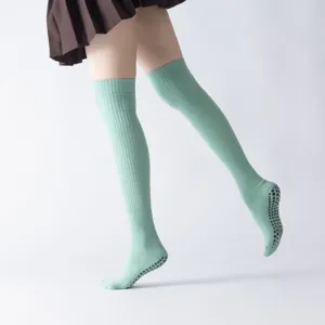 Green over-the-knee yoga socks with anti-slip grips for pilates, thick winter leg warmers.