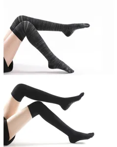 Detail view of over-knee grip yoga socks with five-toe design and non-slip soles.