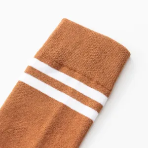 Detail view of brown collegiate style mid-calf yoga socks with dual white stripes.