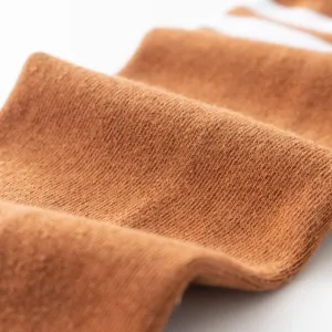 Detailed close-up shot of soft brown knitted fabric, highlighting fine texture and quality.