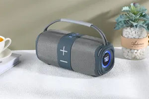 Haut-parleur Bluetooth portable en tissu avec basses profondes et poignée de transport.