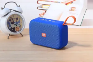 Portable wireless Bluetooth speaker detail view with vibrant blue body and orange strap.