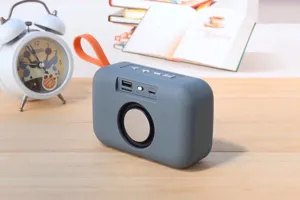 Portable wireless bluetooth speaker with orange strap and deep bass sound, mini outdoor audio.