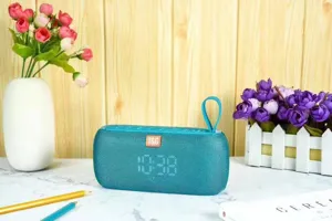 Detailsicht des tragbaren blauen Bluetooth-Lautsprechers mit Stoffgewebe und Uhr.