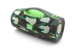 Close-up of portable camouflage Bluetooth speaker with green handle and T&G logo.