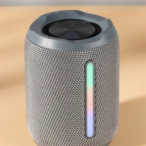 Λεπτομερής όψη φορητού ασύρματου ηχείου Bluetooth με υφασμάτινο σώμα και χρωματιστή φωτεινή λωρίδα.