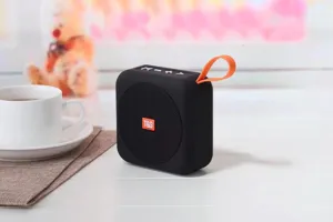 Dettaglio ravvicinato di altoparlante Bluetooth portatile wireless con cinturino arancione.