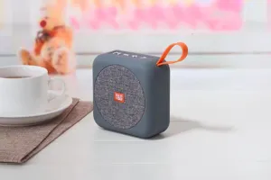 Altoparlante bluetooth portatile senza fili dettaglio con corpo grigio e cinturino arancione.