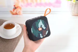 Altoparlante Bluetooth portatile senza fili con griglia mimetica e cinturino arancione.