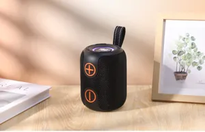 Vue détaillée d'enceinte Bluetooth portable avec corps en maille noire et boutons orange.