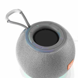 Portable round mini bluetooth speaker with gray woven mesh and handy strap for outdoor use.