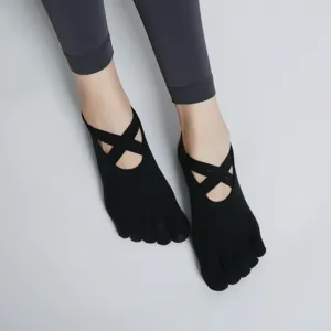 Black five-toe yoga socks with crisscross straps, non-slip pilates socks for women.