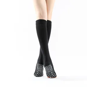 Black knee-high grip yoga socks with anti-slip dots on soles for women fitness and pilates.
