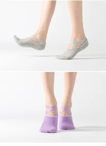 Detail view of women non slip yoga socks featuring cross straps and grip sole for pilates.