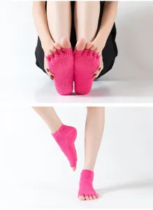 Détail de chaussettes de yoga roses à orteils séparés avec semelle antidérapante pour entraînement.