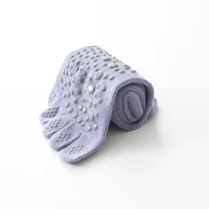Detail view of light purple five toe non slip yoga socks featuring grip dots for fitness.