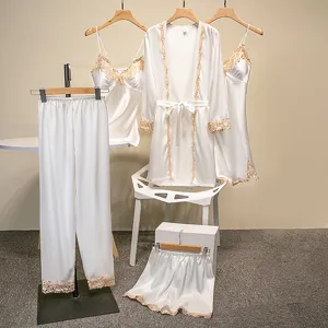 Gedetailleerd overzicht van witte satijnen pyjamaset met fijne gouden kantafwerking.