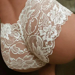 Close-up detail of women's white floral lace low-waist sheer panty for intimate wear.
