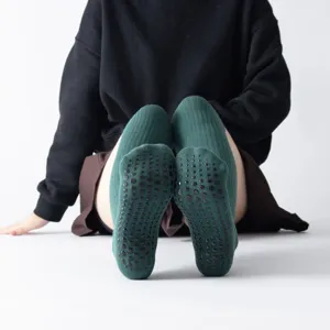 Over-the-knee yoga socks with anti-slip grips, thick winter pilates leg warmers in dark green.